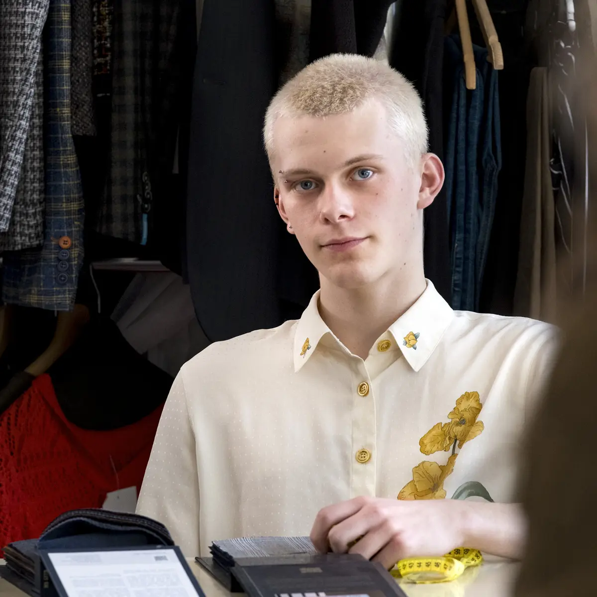 Student bekijkt stoffen tijdens een les in een modeopleiding