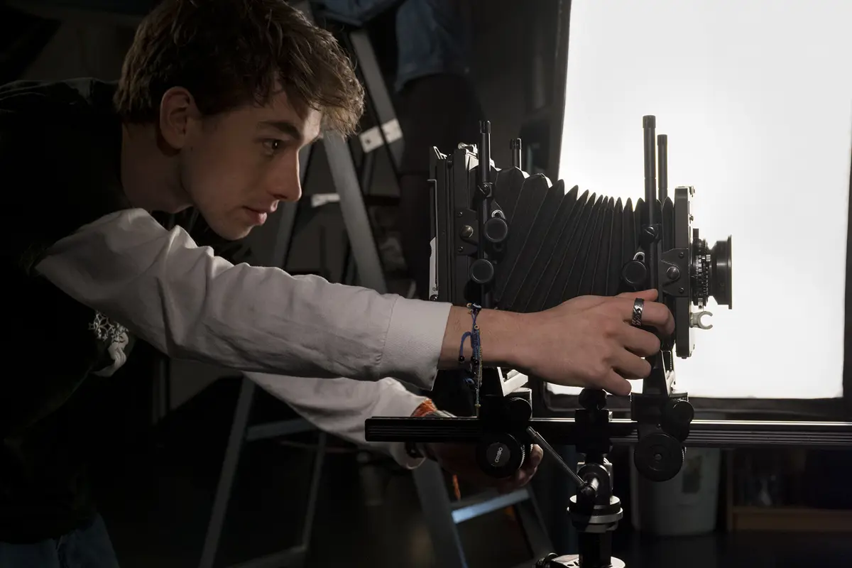 Student werkt met een camera in een studio tijdens een workshop