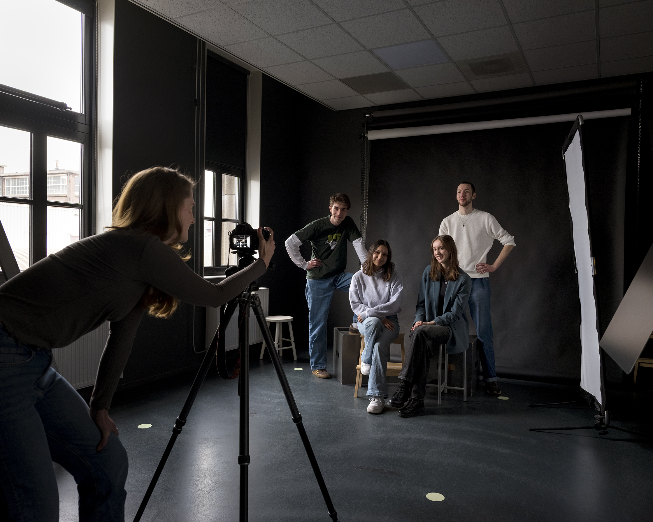 Studenten maken een fotoshoot in een studio tijdens een opleiding fotografie