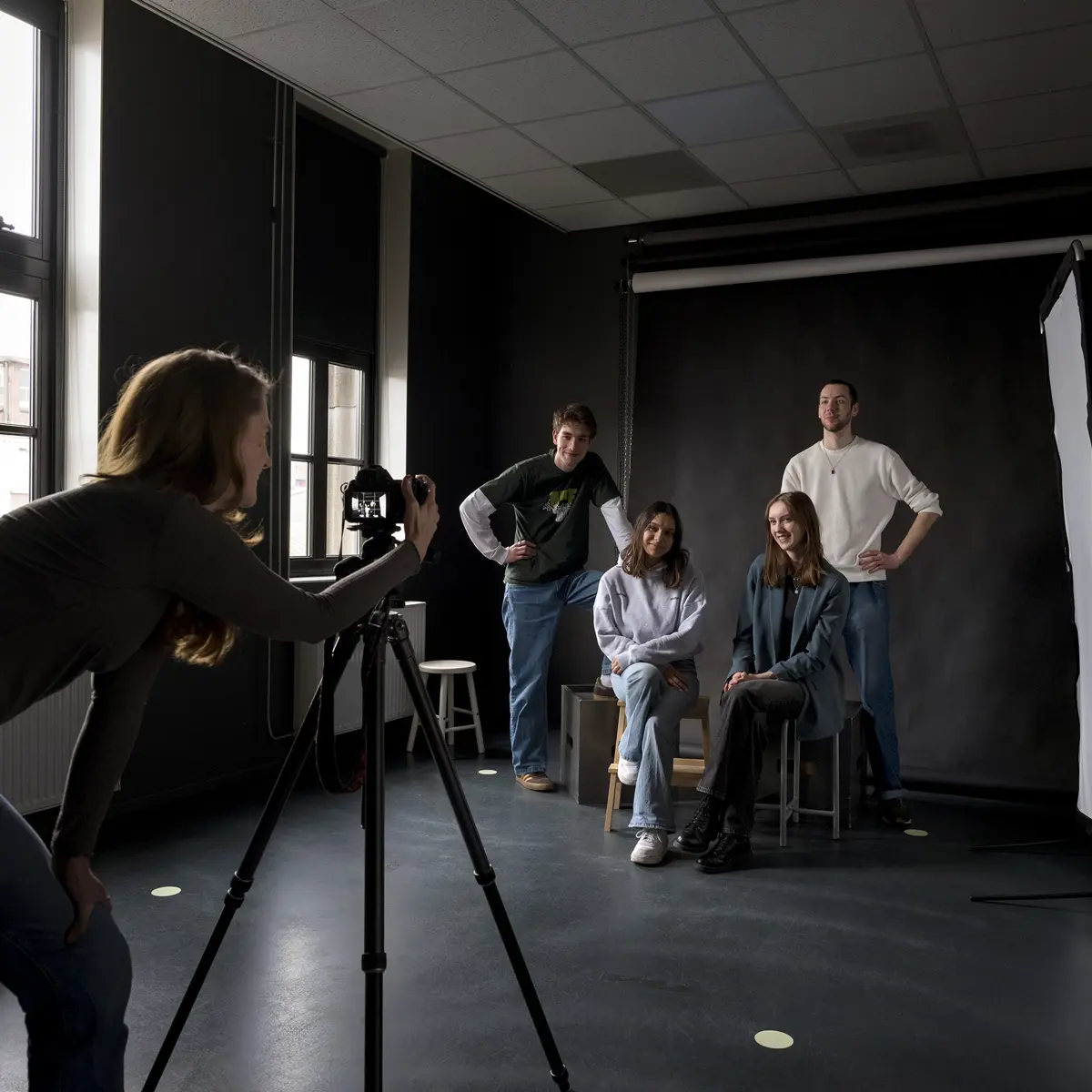 Studenten maken een fotoshoot in een studio tijdens een opleiding fotografie