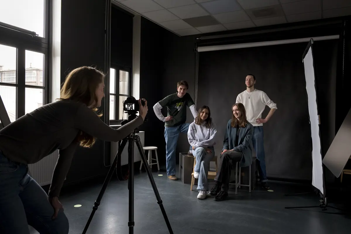 Studenten maken een fotoshoot in een studio tijdens een opleiding fotografie